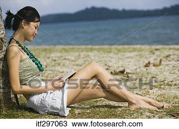 Stock Photo - woman reading 
on a beach. fotosearch 
- search stock 
photos, pictures, 
images, and photo 
clipart