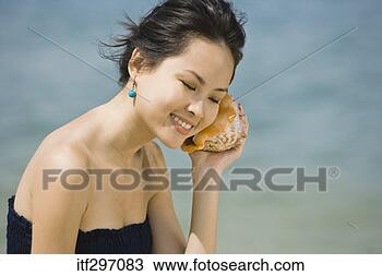 Stock Photo - woman with a seashell. 
fotosearch - search 
stock photos, 
pictures, images, 
and photo clipart