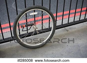 Stock Photo - bicycle tire secured 
to fence. fotosearch 
- search stock 
photos, pictures, 
images, and photo 
clipart