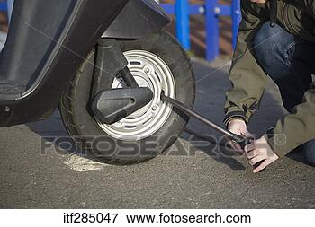 Picture - putting lock on 
scooter tire. 
fotosearch - search 
stock photos, 
pictures, images, 
and photo clipart