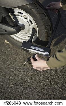 Stock Photo - putting lock on 
scooter tire. 
fotosearch - search 
stock photos, 
pictures, images, 
and photo clipart