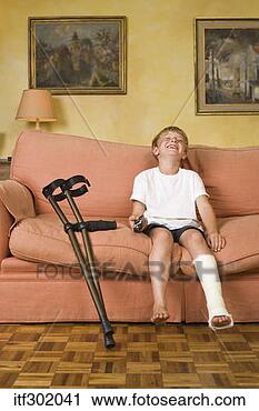 Stock Photography - boy on couch with 
leg cast. fotosearch 
- search stock 
photos, pictures, 
images, and photo 
clipart