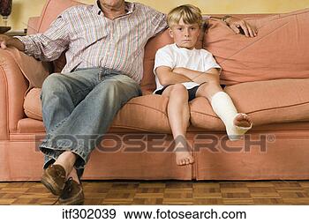 Stock Photograph - boy in leg cast 
sitting with father. 
fotosearch - search 
stock photos, 
pictures, images, 
and photo clipart