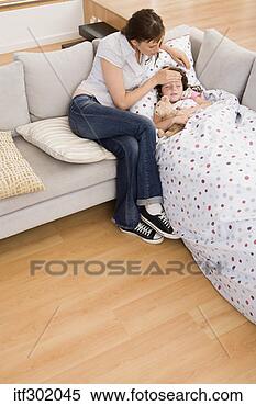Stock Image - sick girl sleeping 
on couch with 
mother. fotosearch 
- search stock 
photos, pictures, 
images, and photo 
clipart