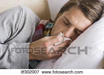 Picture - sick man wiping 
nose with tissue. 
fotosearch - search 
stock photos, 
pictures, images, 
and photo clipart
