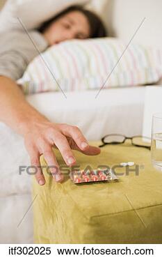 Stock Image - sick woman reaching 
for pills. fotosearch 
- search stock 
photos, pictures, 
images, and photo 
clipart