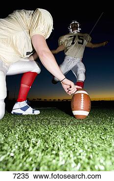 Stock Image - american football 
player attempting 
to kick field 
goal,  teammate. 
fotosearch - search 
stock photos, 
pictures, images, 
and photo clipart