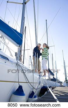 Stock Photography - chivalrous mature 
man assisting 
mature woman to 
board yacht moored 
at. fotosearch 
- search stock 
photos, pictures, 
images, and photo 
clipart