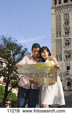 Stock Photo - young couple looking 
at tourist map 
by tower, low 
angle view. fotosearch 
- search stock 
photos, pictures, 
images, and photo 
clipart