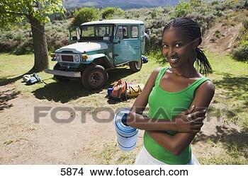 Stock Photo - young woman unloading 
parked jeep at 
start of camping 
holiday. fotosearch 
- search stock 
photos, pictures, 
images, and photo 
clipart