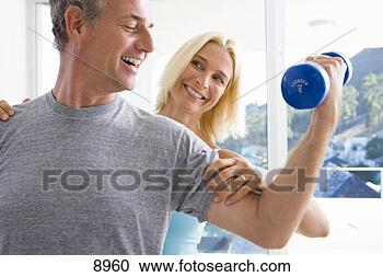 Stock Photography - mature woman smiling 
at mature man 
lifting weights, 
close-up. fotosearch 
- search stock 
photos, pictures, 
images, and photo 
clipart