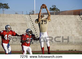 Stock Photo - opposing american 
football players 
competing for 
ball during. fotosearch 
- search stock 
photos, pictures, 
images, and photo 
clipart