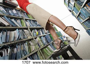 Picture - woman wearing 
skirt and high 
heels,  searching 
for file in office. 
fotosearch - search 
stock photos, 
pictures, images, 
and photo clipart
