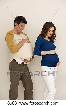 Stock Photo - young pregnant 
woman with hands 
on stomach,  young 
man immitating. 
fotosearch - search 
stock photos, 
pictures, images, 
and photo clipart