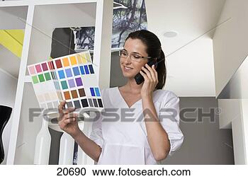 Stock Photography - young businesswoman 
on the phone looking 
at color swatches. 
fotosearch - search 
stock photos, 
pictures, images, 
and photo clipart