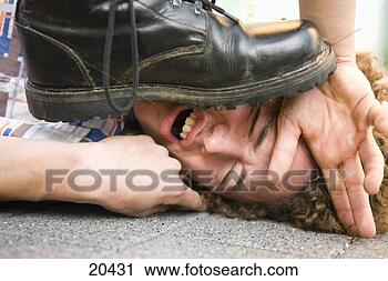 Stock Photography - young man lying 
on ground being 
stepped on by 
someone wearing 
black. fotosearch 
- search stock 
photos, pictures, 
images, and photo 
clipart