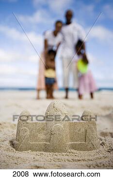 Stock Photo - two generation 
family standing 
on beach,  focus 
on sandcastle 
in. fotosearch 
- search stock 
photos, pictures, 
images, and photo 
clipart