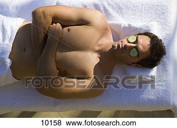 Stock Photo - bare chested man 
having beauty 
treatment,  cucumber 
slices on eyes. 
fotosearch - search 
stock photos, 
pictures, images, 
and photo clipart