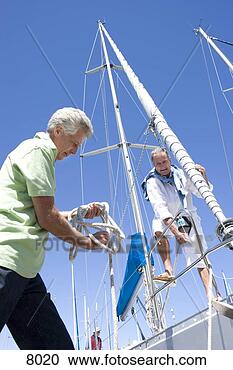 Stock Photography - two mature men 
preparing to set 
sail on yacht, 
 one man untying. 
fotosearch - search 
stock photos, 
pictures, images, 
and photo clipart