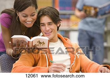 Stock Photography - young man studying 
in library, woman 
showing man book, 
smiling. fotosearch 
- search stock 
photos, pictures, 
images, and photo 
clipart