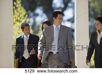 Stock Photograph - four business 
people on the 
move,  businessman 
talking to. fotosearch 
- search stock 
photos, pictures, 
images, and photo 
clipart