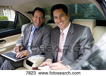 Stock Photo - two businessmen 
sitting in backseat 
of car,  one man 
using laptop. 
fotosearch - search 
stock photos, 
pictures, images, 
and photo clipart