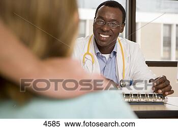 Stock Image - patient sitting 
in doctor's surgery, 
 focus on doctor 
sitting at desk. 
fotosearch - search 
stock photos, 
pictures, images, 
and photo clipart