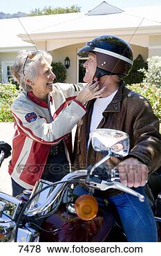 Stock Photo - senior man sitting 
on motorbike on 
driveway,  senior 
woman adjusting. 
fotosearch - search 
stock photos, 
pictures, images, 
and photo clipart