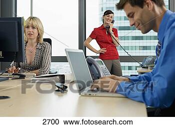Stock Photography - three business 
people working 
in office,  man 
using laptop, 
 woman. fotosearch 
- search stock 
photos, pictures, 
images, and photo 
clipart