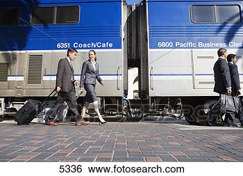 Stock Photo - four business 
people walking 
along railway 
platform beside 
stationary. fotosearch 
- search stock 
photos, pictures, 
images, and photo 
clipart