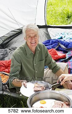 Stock Photo - person serving 
senior man fried 
breakfast on camping 
trip,  man. fotosearch 
- search stock 
photos, pictures, 
images, and photo 
clipart