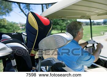 Stock Photo - mature man driving 
golf buggy on 
golf course,  
focus on golf 
clubs. fotosearch 
- search stock 
photos, pictures, 
images, and photo 
clipart