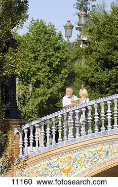 Stock Photography - senior couple 
by railings on 
ornate bridge, 
low angle view. 
fotosearch - search 
stock photos, 
pictures, images, 
and photo clipart