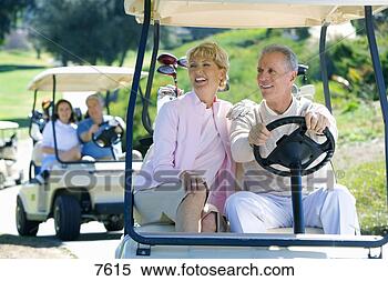 Stock Image - two mature couples 
driving golf buggies 
along golf course 
pathway. fotosearch 
- search stock 
photos, pictures, 
images, and photo 
clipart
