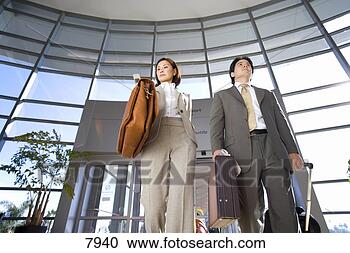 Stock Photography - businessman and 
woman walking 
with luggage in 
tow in airport. 
fotosearch - search 
stock photos, 
pictures, images, 
and photo clipart