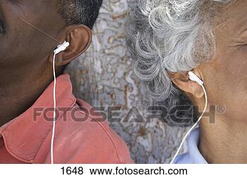 Stock Photo - senior couple 
listening to mp3 
player,  sharing 
earbud headphones. 
fotosearch - search 
stock photos, 
pictures, images, 
and photo clipart