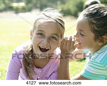 Picture - girl (7-9) whispering 
in friend's ear, 
second girl gasping, 
close-up. fotosearch 
- search stock 
photos, pictures, 
images, and photo 
clipart