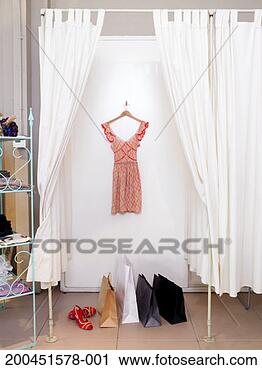 Stock Photography - dress hanging 
in dressing room, 
shopping bags 
on floor. fotosearch 
- search stock 
photos, pictures, 
images, and photo 
clipart