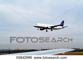 Stock Photo - commercial airplane 
taking off under 
cloudy skies, 
 with wing of. 
fotosearch - search 
stock photos, 
pictures, images, 
and photo clipart