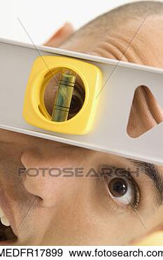 Stock Photograph - man peeping through 
hole in level 
scale, close-up. 
fotosearch - search 
stock photos, 
pictures, images, 
and photo clipart
