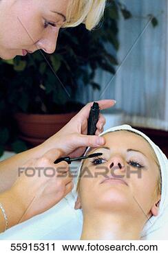 Stock Photography - mid adult woman 
applying mascara 
on a mid adult 
woman's eye. fotosearch 
- search stock 
photos, pictures, 
images, and photo 
clipart