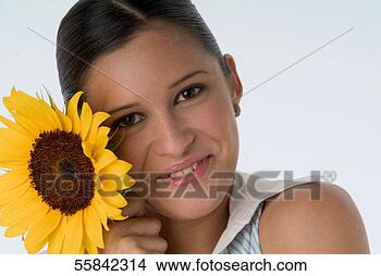 Stock Photo - portrait of young 
woman holding 
sunflower, close-up. 
fotosearch - search 
stock photos, 
pictures, images, 
and photo clipart