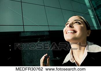 Stock Photo - smiling young 
businesswoman 
holding glasses 
and looking up, 
close-up. fotosearch 
- search stock 
photos, pictures, 
images, and photo 
clipart