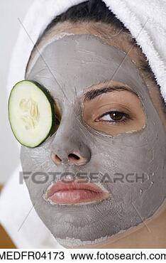 Stock Photo - a young woman 
with pack on her 
face and cucumber 
slice on one eye. 
fotosearch - search 
stock photos, 
pictures, images, 
and photo clipart