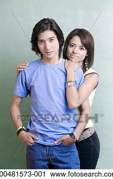 Stock Photography - teen couple (17-19) 
standing against 
green wall. fotosearch 
- search stock 
photos, pictures, 
images, and photo 
clipart