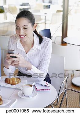 Stock Image - woman in a cafè 
texting on her 
mobile phone. 
fotosearch - search 
stock photos, 
pictures, images, 
and photo clipart
