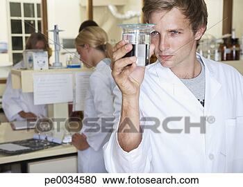 Stock Photography - man in a busy 
laboratory measuring 
liquids. fotosearch 
- search stock 
photos, pictures, 
images, and photo 
clipart