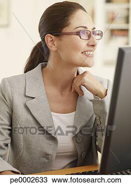 Stock Photo - portrait of businesswoman 
at computer smiling. 
fotosearch - search 
stock photos, 
pictures, images, 
and photo clipart