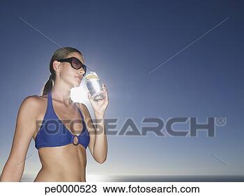 Stock Photo - woman in bikini 
and sunglasses 
with cold beverage 
outdoors. fotosearch 
- search stock 
photos, pictures, 
images, and photo 
clipart