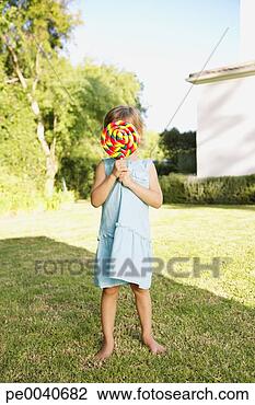 Stock Photo - a young girl holding 
a large lollipop. 
fotosearch - search 
stock photos, 
pictures, images, 
and photo clipart